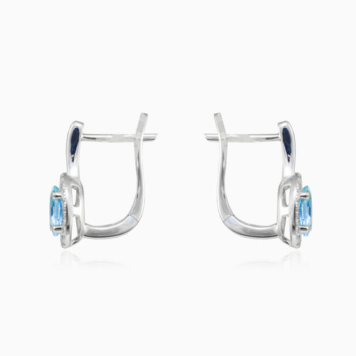 White gold earrings with blue topaz and diamond halo design