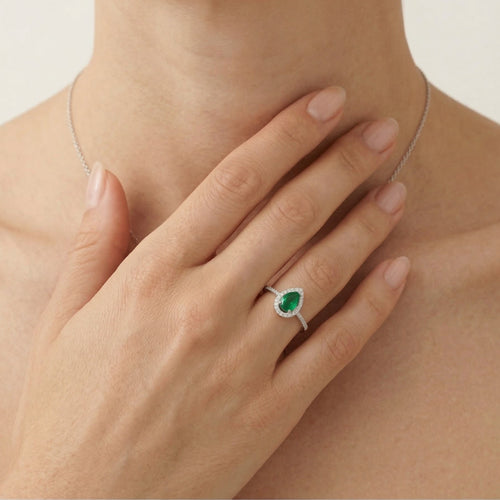 White gold ring with diamonds and pear cut emerald