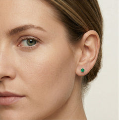 Petites boucles d’oreilles clous en argent avec émeraude synthétique.