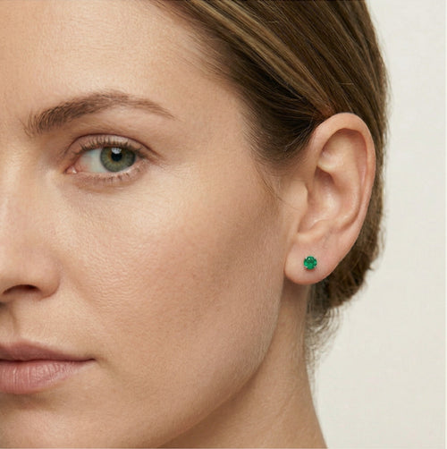 Petites boucles d’oreilles clous en argent avec émeraude synthétique.