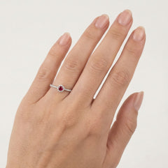 Fine bague en or blanc avec rubis et halo de diamants