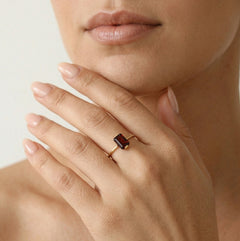 Anillo de granate corte esmeralda en oro amarillo.