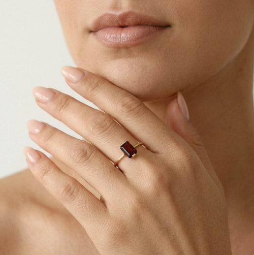 Anillo de granate corte esmeralda en oro amarillo.