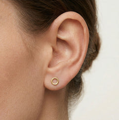 Boucles d'oreilles puces rondes en or jaune avec zircon cubique dans un cadre.