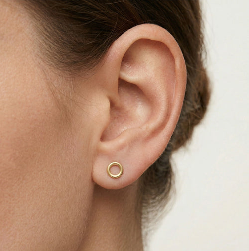 Boucles d'oreilles puces rondes en or jaune avec zircon cubique dans un cadre.