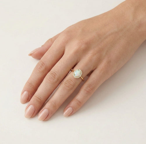 Ovaler Goldring mit weißem Opal und Halo