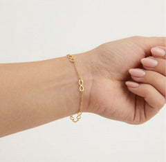 Brazalete de oro sencillo con patrón de infinito múltiple.