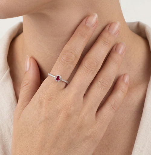 Fine bague en or blanc avec rubis et halo de diamants