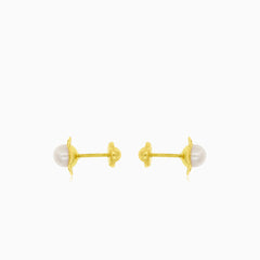 Gold earrings with an engraved flower outline and a white round pearl