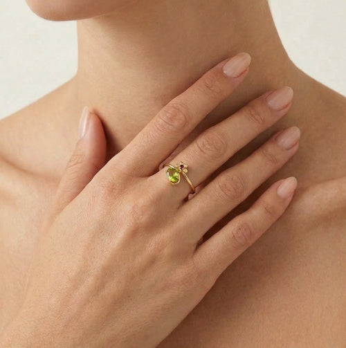 Bague en or avec moldavite ovale, accents floraux et grenats