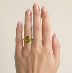 Oval moldavite gold ring with ten prongs