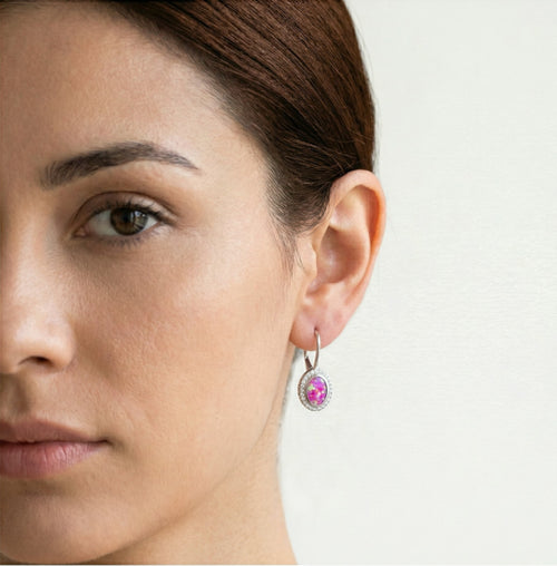 Boucles d'oreilles à levier en or avec opale rose ovale sertie.