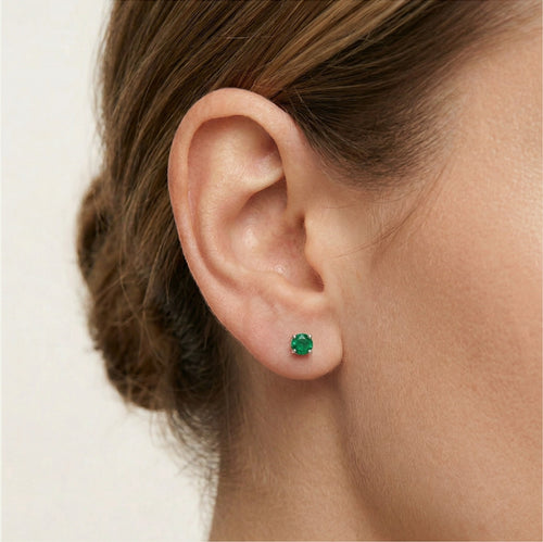 Petites boucles d’oreilles clous en argent avec émeraude synthétique.