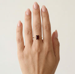 Anillo de granate corte esmeralda en oro amarillo.