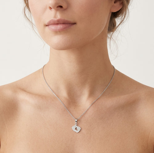 Pendentif délicat en or blanc en forme de petits pieds bébé