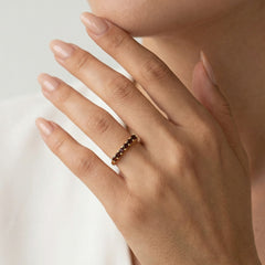 Bague en or jaune avec grenats taillés en rond.