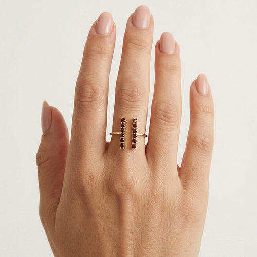 Gold ring with garnets along finger