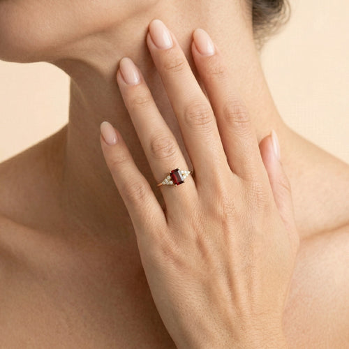 Bague élégante en grenat taille émeraude avec zirconiums.