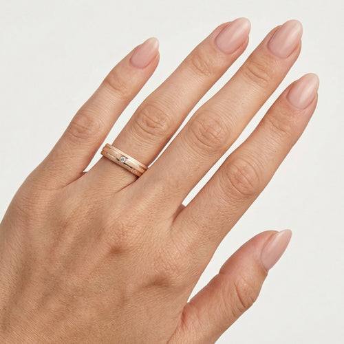 Rose gold wedding ring with flat polished lines and stone