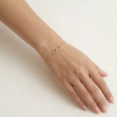 Brazalete de oro sencillo con símbolo de infinito.