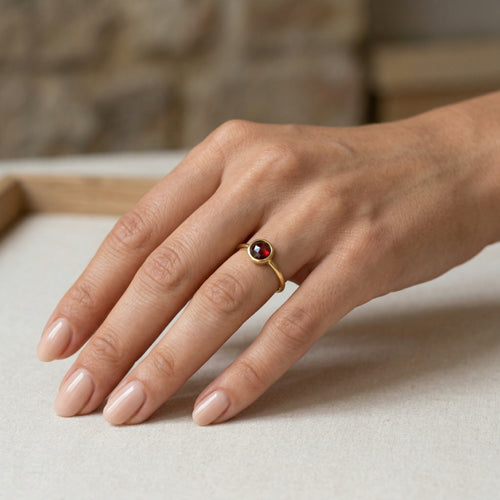 Simple yellow gold ring with solitaire garnet