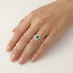 White gold ring with diamonds and pear cut emerald