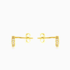 Boucles d'oreilles puces rondes en or jaune avec zircon cubique dans un cadre.